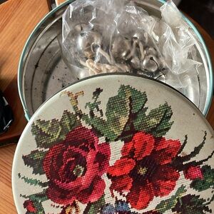 Vtg tin box. Needlepoint motif. Bag of bells inside. VG vintage condition.  6x2